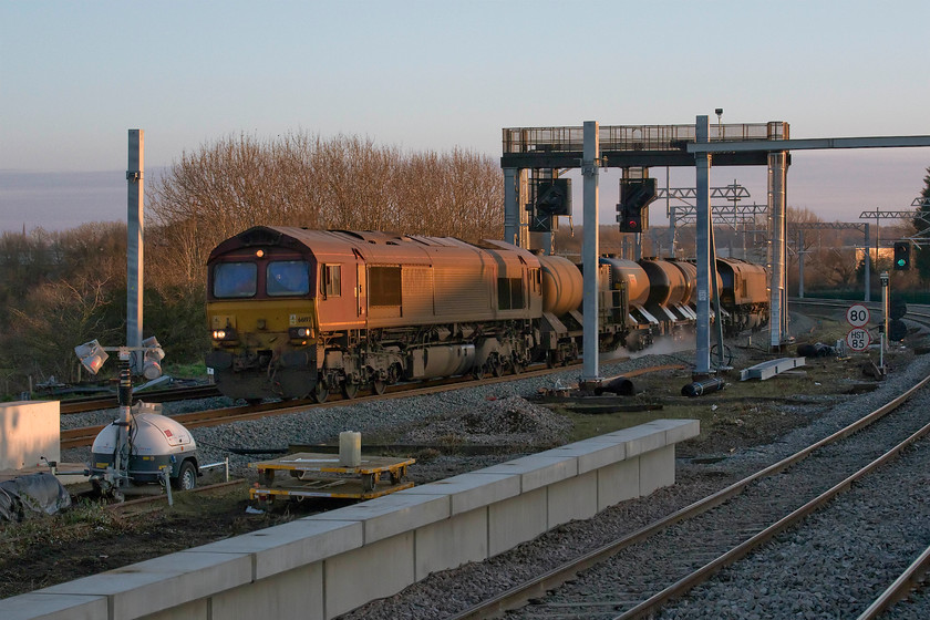 66197 & 66143, 11.53 West Hampstead North-Toton, Wellingborough station 
 It is only 15.15 in the afternoon and yet the sun is now very low in the sky creating some very long and deep shadows. the 11.53 West Hampstead to Toton railhead treatment train just catches the last vestiges of the afternoon sun as it approaches Wellingborough station lead by 66197 and an equally filthy 66143 at the rear. 
 Keywords: 66197 66143 11.53 West Hampstead North-Toton Wellingborough station RHT railhead treatement EWS