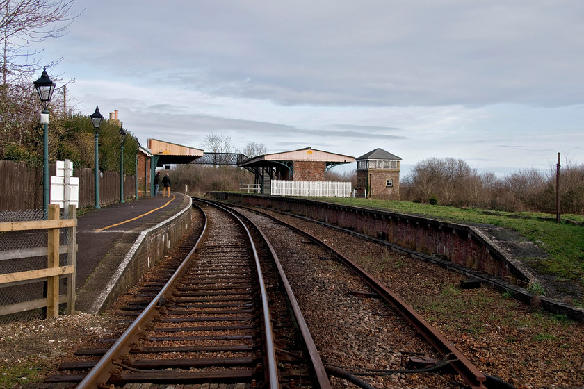 Brading station 
 Taken from a foot crossing to the south of Brading station the buildings, former trackbed and preserved signal box can be seen. The station is in a delightfully rural location and once acted as the junction for the short branch that led down to Bembridge for which there was a bay platform between the signal box and the station. It was announced in the summer of 2019 that the passing loop is to be reinstated at Bembridge to increase capacity during peak times. Indeed, whilst we were on the station there was a gaggle of staff from Network Rail and South West Trains surveying various things, walking around with clipboards and taking photographs. 
 Keywords: Brading station