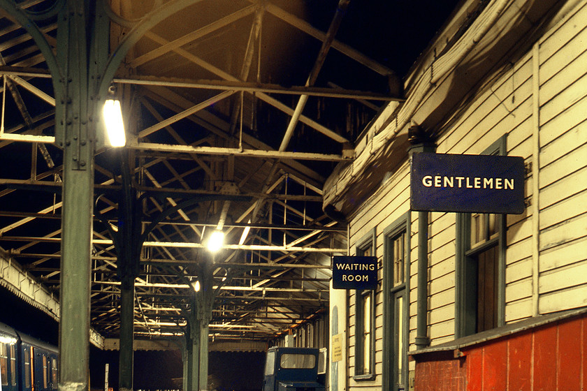 Enamels & roof work, New Holland Pier station 
 On arrival at a cold, a wild New Holland Pier was like going back to another age! The station, some distance from the shore on the wooden pier, was festooned with blue (British Railways Eastern Region) enamels and items even older than that. The whole atmosphere was enhanced by the darkness and the snow that was now falling quite heavily. Notice the DMU just putting in an appearance to the far left. 
 Keywords: Enamels roof work New Holland Pier station