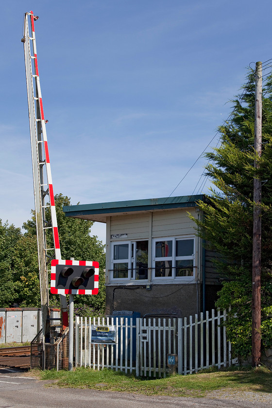 Kidwelly signal box (BR, 1950s) 
 Another view of Kidwelly signal box, this time from the side and back showing clearly the full barriers. The use of this type of barrier, even though favoured by Network Rail, is a little bit of surprise here as the road they protect goes nowhere apart from to a few houses down by the Gwendraeth estuary. Kidwelly's box is the intermediate block post between Pembrey to the east and Ferryside to the west and must be a lovely, quiet place to work. 
 Keywords: Kidwelly signal box