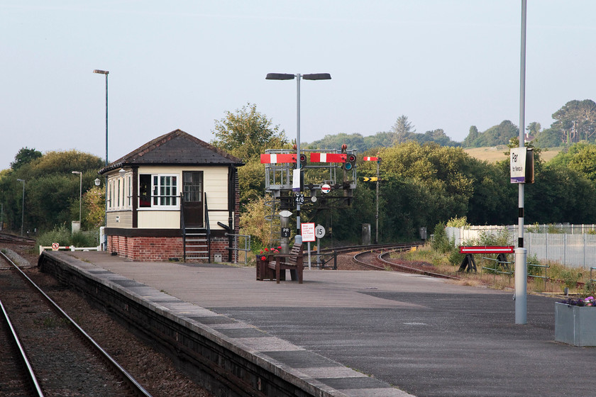 Par signal box (GW, c.1879) & station 
 A deserted Par station taken from the train as we paused our journey. It shows the signal box situated on the platform end. The box is actually double the length from when it was originally constructed and opened in about 1879. It is built to the Great Western's first standardised design that utilised a hipped roof arrangement. The line off to the right controlled by the small bracket is the Newquay branch. 
 Keywords: Par signal box station