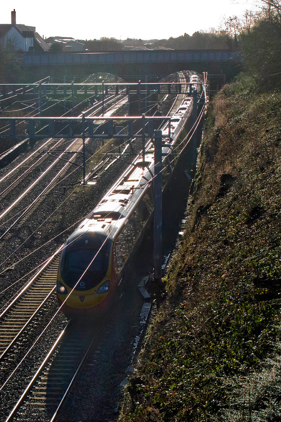 Class 390, VT, unidentified down working, Hyde Road bridge 
 The perils of taking photographs looking due south on a Winter's morning! A class 390 Pendolino speeds through Roade about to pass under Hyde Road bridge with an unidentified northbound service. 
 Keywords: Class 390 VT unidentified down working Hyde Road bridge Virgin West Coast Pendolino