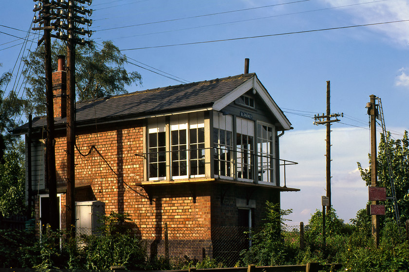 Blankney signal box (GN, 1928) 
 An utterly antiquated scene at Blankney level crossing! Where do we start with the list of railway infrastructure from a bygone era? We could begin with the superb array of telegraph wires and posts that carried communications between the boxes. The Great Northern slotted concrete signal post stands protecting the crossing complete with two LNER cast notices. The superb box is a Great Northern structure dating from 1928 and is what appears to be original condition having not been modified, outwardly at least! Finally, notice the LNER small blue enamel nameplate on the end of the box. The whole scene here evokes an atmosphere that has completely disappeared from today's railways that makes this one of my all-time top ten favourite photographs! 
 Keywords: Blankney signal box Great Northern GNR