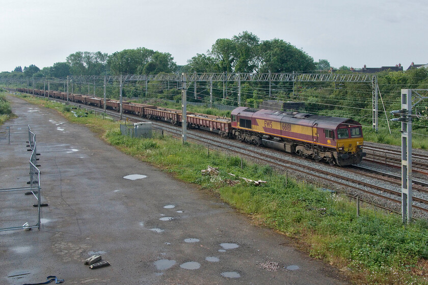 66181, 07.00 Camden South Junction-Bescot Engineers (6R02, 21E), site of Roade station 
 An early Sunday morning engineer's working from London is a pretty regular fixture, on some weeks there are two within a short time of each other. Running as 6R02 the 07.00 Camden South Junction to Bescot is seen passing Roade hauled by EWS liveried and branded 66181. 
 Keywords: 66181 07.00 Camden South Junction-Bescot Engineers 6R02 site of Roade station EWS