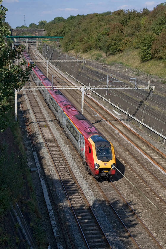 Class 221s, VT 12.50 Birmingham New Street-London Euston (1B24), Roade cutting 
 An unidentified pair of Class 221 Voyagers pass through Roade cutting working the 12.50 Birmingham New Street to Euston Virgin West Coast service. I never cease to be amazed at the number of times that I observe a diesel unit operating under the wires that always seems such a waste of Virgins resources. I am not a train planner and am not fully aware of the logistics associated with it but is their full attention paid to this situation? 
 Keywords: Class 221 12.50 Birmingham New Street-London Euston 1B24 Roade cutting Virgin West Coast Voyager