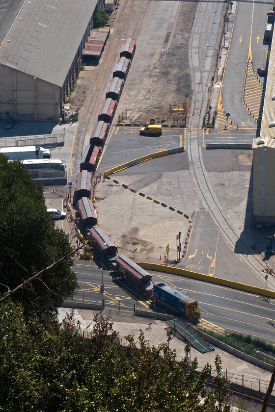 1009, shunting wagons, Barcelona Harbour, from Montjuc Castle 
 The commanding view of the vast and very busy Barcelona Harbour is impressive from the Montjuc Castle. Looking down from the castle ramparts shunting locomotive 1009 operated by Ferrocarrils de la Generalitat de Catalunya on the harbour's extensive network of tracks is seen. I believe that it is hauling a rake of potash wagons on the network's metre gauge track. From this viewpoint, the locomotive bears a strong resemblance to a Class 20 if just a little shorter and I bet there would be no English Electric sound from its engine! 
 Keywords: 1009 shunting wagons Barcelona Harbour from Montjuc Castle