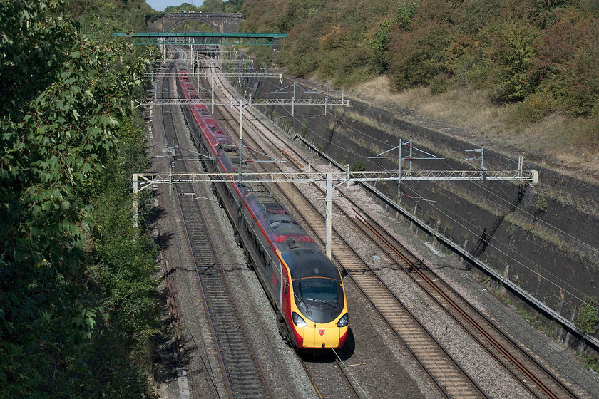 390124, VT 11.50 Birmingham New Street-London Euston (1B15, RT), Roade Cutting 
 390124 'Virgin Venturer' passes south through the 180 year old Roade Cutting with the 11.50 Birmingham New Street to London Euston. It's testament to the foresight and technology used by Robert Stevenson when the cutting was constructed that 180 years on from its opening it's still doing what it was designed for. 
 Keywords: 390124 1B15 Roade Cutting