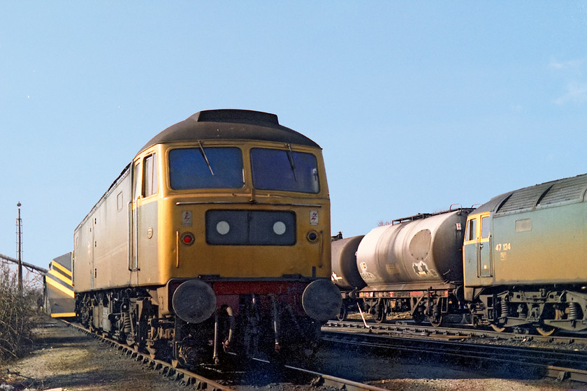 47256 & 47124, Westbury MPD 
 On-shed at a sunny Westbury MPD are 47256 and 47124. I was really pleased to see 47256 for two reasons, firstly it was a cop form me and secondly, it was a celebrity loco. at this time as it was still in its green livery. In fact, it was the last of the class to be repainted into Rail Blue from green but this green was not its original paintwork as, surprisingly it was repainted following fire damage in 1974. Also in this picture are some of Westbury's resident fuel tankers used to replenish the locomotives that came on-shed. Also to the left is a snow plough that no doubt saw some use during the recent heavy snow that had crippled the railways a few weeks previously. 
 Keywords: 47256 47124 Westbury MPD