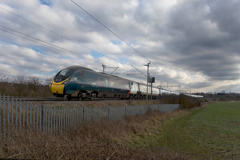 390127, VT 10.58 London Euston-Manchester Piccadilly (1H21, RT), Wilson's Crossing 
 Under a very cold and wintry sky, 390127 climbs away from Northampton past Wilson's Crossing working the 10.58 Euston to Manchester Piccadilly. Diversions off the mainline through Northampton are not uncommon but this is now the fourth week of a diversion on the down line due to repairs being undertaken to a collapsed embankment at Hillmorton Junction (Rugby) caused by recent heavy rain. 
 Keywords: 390127 10.58 London Euston-Manchester Piccadilly 1H21 Wilson's Crossing Avanti West Coast Pendolino