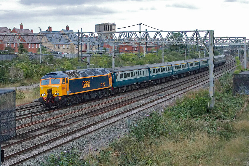 57310, 15.48 Wembley Yard-Burton-ot-Wetmore Sidings (5D70, 58E), site of Roade station 
 Having worked to the Scottish Border the previous day and visiting two rail-connected MoD bases (Eastriggs and Longtown) the empty stock is returning back to its base at Burton-on-Trent. 57310 leads the stock as the 5D70 ex Wembley Yard which arrived nearly an hour early, as is often the case on a Sunday afternoon. What a contrast with the weather yesterday, see...... https://www.ontheupfast.com/p/21936chg/30059776231/x57310-eastriggs-eloper-06-20-watford 
 Keywords: 57310 15.48 Wembley Yard-Burton-ot-Wetmore Sidings 5D70 site of Roade station