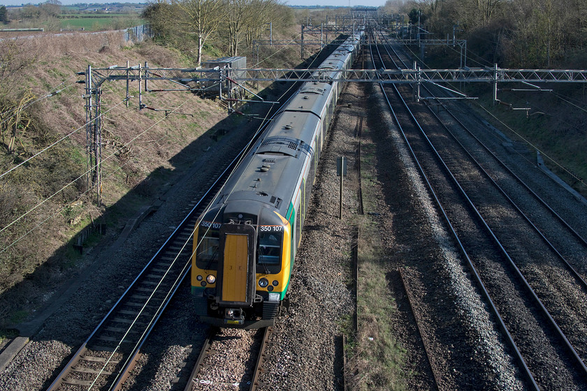 350107, LN 14.24 London Euston-Northampton (2Z33, 4E), Victoria bridge 
 One of the three-set emergency timetable workings passes Victoria bridge a short distance north of Hanslope Junction. The 14.24 Euston to Northampton 2Z33 London Northwestern service is led by 350107 with two other sets behind it. 
 Keywords: 350107 14.24 London Euston-Northampton 2Z33 Victoria bridge London Northwestern Desiro