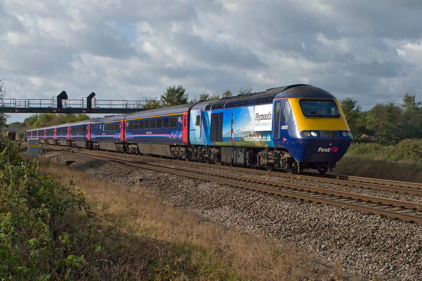 43163, GW 11.55 Cardiff Central-London Paddington (1L54), South Marston foot crossing SU193869 
 43163, with its unique 'Plymouth-Britain's Ocean City' livery passes South Marston just a short distance east of Swindon with the 1L54 11.55 Cardiff to Paddington service. The full-body vinyls have recently been applied with this power car previously carrying advertising promoting Singapore Airlines of all things! 43163 was the rear power car of the 10.32 Swansea to Paddington service that collided with a stone train at Southall on 19.09.97. It survived but the leading car, 43173, was cut up. Unfortunately, seven people died in the crash. 
 Keywords: 43163 11.55 Cardiff Central-London Paddington 1L54 South Marston foot crossing SU193869 First Great Western HST