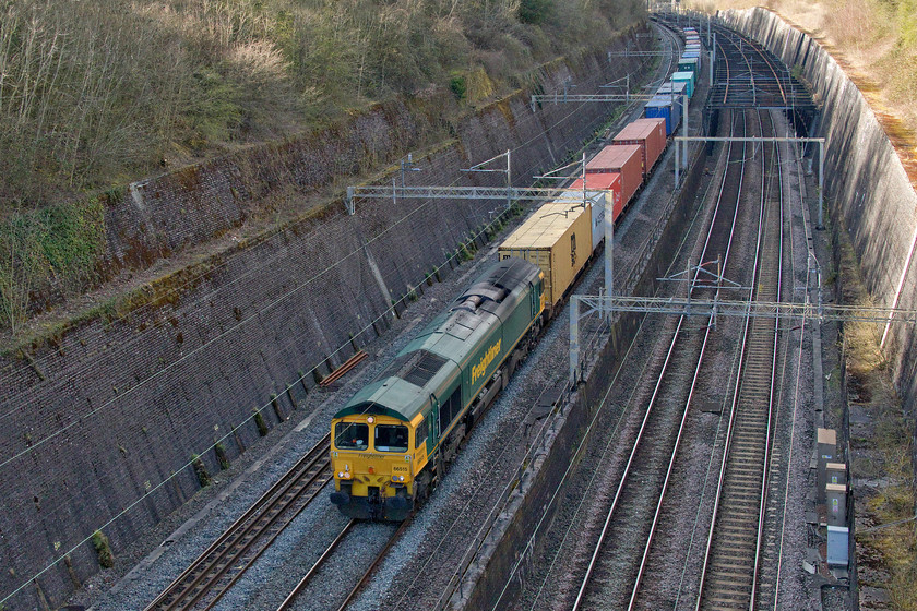 66515, 12.57 Birch Coppice-Felixstowe North (4L57, 3E), Roade cutting 
 66515 swings into Roade cutting on the up fast having taken the Weedon loop thus avoiding Northampton. Normally this is extremely rare but given the dearth of passenger services due to the Covid-19 emergency timetable there are plenty of paths available. The 12.57 Birch Coppice to Felixstowe North 4L57 appears to be well loaded but looks can be deceiving as the boxes visible were the only ones being conveyed with the rest of the train being composed of empty flats as a result of the marked reduction of exports. 
 Keywords: 66515 12.57 Birch Coppice-Felixstowe North 4L57 Roade cutting Freightliner