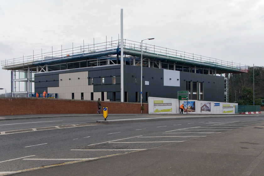 New station taking shape, from Westbridge 
 I am yet to be convinced by the design of the new station at Northampton but it is far from complete so I will reserve my final judgement! The main building takes shape from the town's busy Westbridge surprisingly traffic-free! There is to be no access from this side with the main entrance located facing the trees to the right. 
 Keywords: New station taking shape from Westbridge