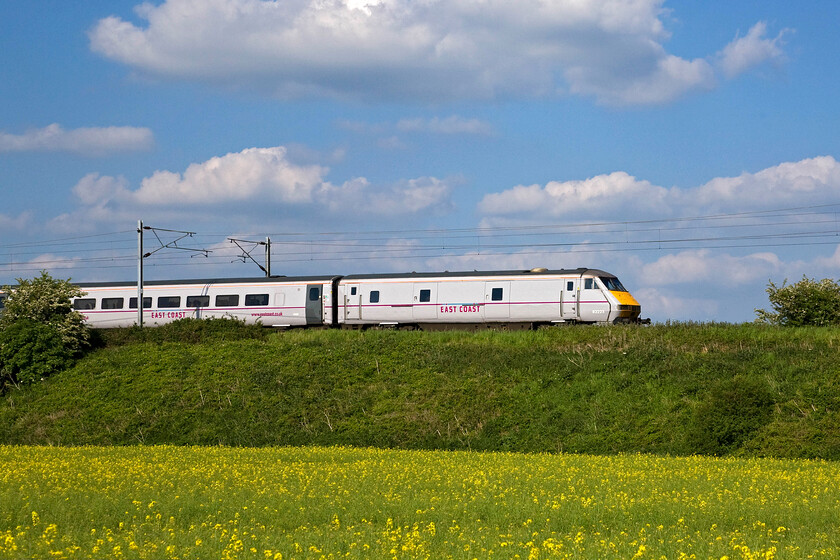 82223, GR 13.00 Edinburgh Waverley-London King's Cross (1E16), Yaxley TL194921 
 82223 pilots the 13.00 Edinburgh to King's Cross service past Yaxley just south of Peterborough. The field of oilseed rape (Brassica napus) in the foreground has just gone over being past its resplendent yellow best of a week or so ago! 
 Keywords: 82223 13.00 Edinburgh Waverley-London King's Cross 1E16 Yaxley TL194921