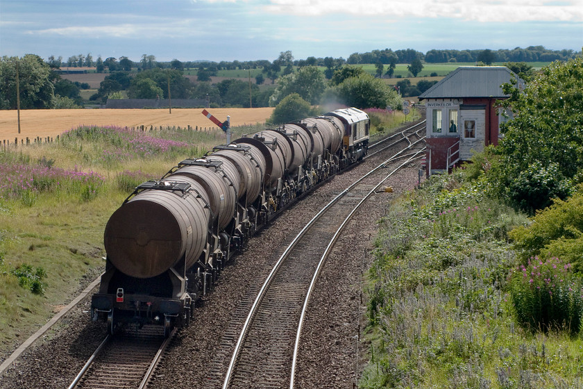 66014, 14.27 Dyce Raiths Farm FD-Mossend Down Yard, Inverkeilor NO668491 
 60014 accelerates past Inverkeilor signal box leading the 14.27 Dyce Raiths farm fuel depot to Mossend. This was a really pleasant spot in rural Angus that Andy and I would have loved to have spent a little time at, however, it was approaching 16.00 and we needed to carry on towards Dundee. 
 Keywords: 66014 14.27 Dyce Raiths Farm FD-Mossend Down Yard Inverkeilor NO668491