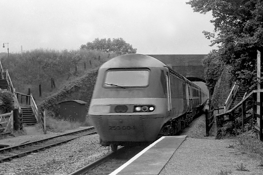 253004, unidentified diverted London Paddington working, Avoncliff station 
 Passing under the Kennet and Avon canal aqueduct at Avoncliff 253004 weaves its way along the Avon Valley on its way towards London. For the passengers, this delightful bit of railway would make a welcome (if not a little inconvenient in terms of timings!) change from the usual route along Brunel's billiard table route.The diversion was caused by the GWML being closed at Challow due to a freight derailment with all trains going via the Berks and Hants route. Notice that this power car has one of its plastic covers missing from the lights. This was a common problem some year or so after their introduction and many were seen suffering from this affliction. Thanks to Kevin Daniel for this information.