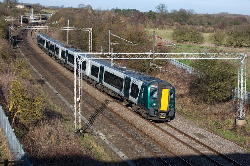 350254, LN 10.02 Crewe-London Euston (1U26, 4L), A45 Weedon bypass bridge 
 London NorthWestern's 350254 sweeps around one of the many curves and steeply cambered sections of track on the Weedon loop line working the 10.02 Crewe to Euston 'fast' service. I am standing at recently created spot on the embankment just below the bridge of the recently opened Weedon bypass. Indeed, the shadow of the bridge behind me can be seen just in front of the train. 
 Keywords: 350254 10.02 Crewe-London Euston 1U26 A45 Weedon bypass bridge