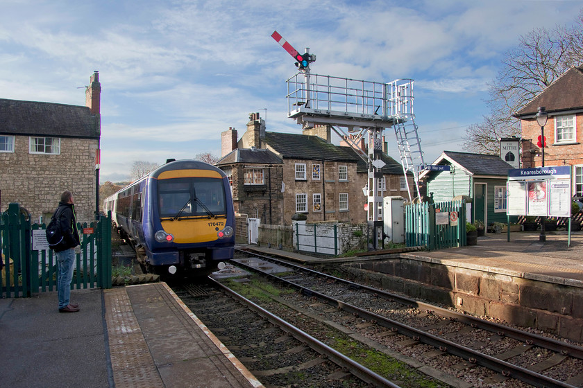 170472, NT 11.11 York-Leeds (2C33, 11L), Knaresborough station 
 Having alighted from 172472 at Knaresborough, Mike watches it leave the station and cross the magnificent viaduct that was opened in 1851. A clearer view of the viaduct can be seen at.... https://www.ontheupfast.com/v/photos/21936chg/28633907404/pacer-13-11-york-leeds-2c33-knaresborough Most of this route still operates absolute block with a number of signal boxes having control of the line. Knaresborough's box can be seen to the right of the rear cab of the 11.11 York to Leeds service, being built into the end of the row of terraced cottages 
 Keywords: 170472 11.11 York-Leeds (2C33, 11L), Knaresborough station