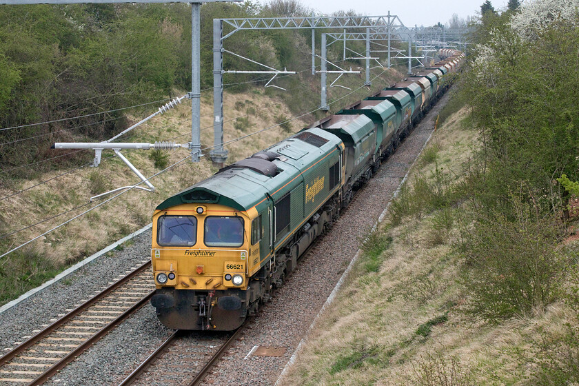 66621, 23.50 East Usk Yard-Radlett Redland Roadstone (6Z39, 5E), Wymington SP955638 
 66621 working hard on the climb towards Sharnbrook tunnel near the village of Wymington leads the 23.50 East Usk Yard (Newport) to Radlett stone train running as 6Z39 (Thanks to Mike for identifying the reporting number). This train follows an extraordinary route from South Wales to Hertfordshire via the Marches line to Shrewsbury then through the heart of the West Midlands to Burton-on-Trent thence south on the MML to Syston junction where it heads east again to Manton Junction then to Corby. Finally, it dashes south on the MML again arriving at its destination. I am not at all sure why it takes this nocturnal and convoluted route that does seem rather wasteful of resources with many more seemingly direct routes available? 
 Keywords: 66621 23.50 East Usk Yard-Radlett Redland Roadstone 6Z39 Wymington SP955638 Freightliner