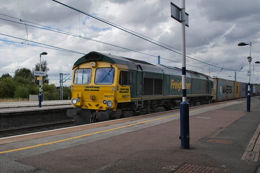 66571, 11.24 Leeds FLT-Ipswich SS (4L85), Grantham station 
 66571 bowls through Grantham station leading the 4L85 11.24 Leeds FLT to Ipswich (for Felixstowe) Freightliner service. The driver will be working the locomotive hard at this point getting a good run at Stoke Bank the climb of which starts about here. There is now a sustained five-mile climb of 1:200 until the summit in the tunnel. 
 Keywords: 66571 11.24 Leeds FLT-Ipswich SS 4L85 Grantham station Freightliner