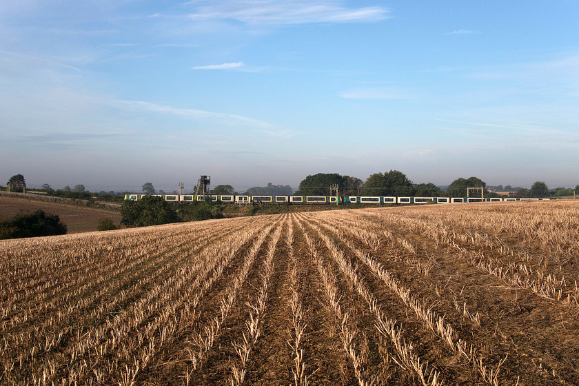 Class 350s, LN 07.05 Northampton-London Euston (2N04, 1L), between Roade & Ashton SP765508 
 The 07.05 from Northampton to London Euston left its start point some six minutes previous to this photograph being taken between Roade and Ashton. It is seen passing a field of harvested oilseed rape that is awaiting ploughing before sowing of next summer's wheat. The class 350 Desiros have been the mainstay of local services on the southern WCML since there introduction in 2007. Some twelve years later, the 350 2XX series is due to come off lease in the next few months to be replaced by the former TPE 3504XXs and the suburban class 730s. 
 Keywords: Class 350s 07.05 Northampton-London Euston 2N04 between Roade & Ashton SP765508