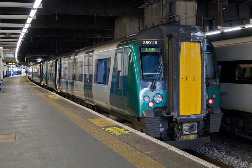 350118, LN 13.23 London Euston-Birmingham new Street (1Y39, 2L), London Euston station 
 Our train back from London to Northampton waits in the gloominess of Euston station. My wife and I travelled aboard the 1Y39 13.23 service to Birmingham New Street worked by 350118. It was pleasing that there was a full ticket inspection during the journey undertaken by a very professional guard who also made concise and useful announcements and not a 'station stop' to be heard; this makes a pleasant and reassuring change from the usual London Northwestern experience! 
 Keywords: 350118 13.23 London Euston-Birmingham new Street 1Y39 London Euston station London Northwestern Desiro