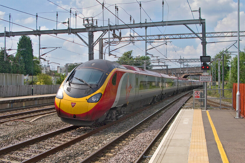 390029, VT 13.47 Liverpool Lime Street-London Euston (1A40), Lichfield Trent Valley station 
 390029 'City of Stoke-on-Trent' sweeps southwards through Lichfield station working the 1A40 13.47 Liverpool to Euston train. Notice the section of single track beyond the platform end. This is the northern end of the small spur that diverges from the freight-only section of line from Wichnor Junction to Lichfield Trent Valley High Level station that straddles the WCML behind me. 
 Keywords: 390029 13.47 Liverpool Lime Street-London Euston 1A40 Lichfield Trent Valley station Virgin West Coast Pendolino City of Stoke-on-Trent