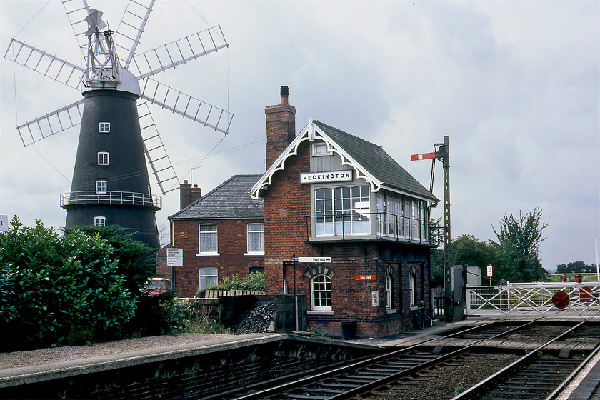 Heckington signal box (GN, 1876) 
 A typically hackneyed photograph of Heckington signal box usually includes the grand windmill in the background and mine is no exception! However, back in 1980, when this one was taken, tree growth allowed for a far more open view than is possible today. Notice the small shrubs on the up platform, they have now morphed into huge trees that tower above the signal box! The Great Northern Railway box was built in 1876 and is now Grade II listed. According to Historic England's reasons for designation, 'it is a particularly good example of the Type 1 (box), an especially attractive signal box design with a great deal of character. The box has elaborate detailing, such as the pointed Gothic arch polychromatic windows which are thought to be unique for the GNR.' It is located in the village of the same name on the Skegness line east of Sleaford. Notice the GER slotted concrete signal post next to the box. 
 Keywords: Heckington signal box