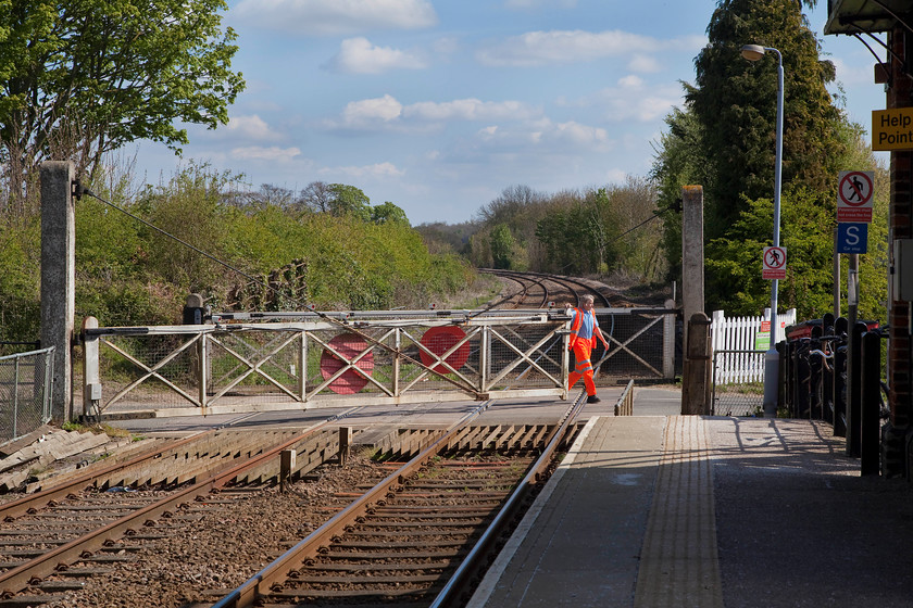 Signalman opening the gates, Dullingham station 
 A scene getting increasingly rare on the network, a signalmen opening the crossing gates after the passage of a train. Also, notice that the gates are of the vintage design that one would expect from some years ago, no modern day replacements here. The passage of trains is fairly infrequent at Dullingham so the signalman was not kept too busy going up and down the steps to the Great Eastern signal box just seen on the far right of the picture 
 Keywords: Signalman opening the gates, Dullingham station