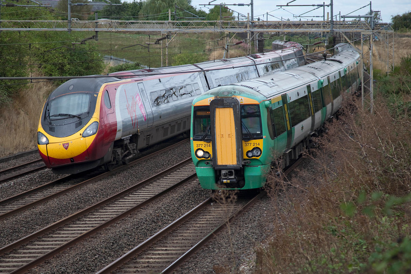 390131, VT 10.35 Manchester Piccadilly-London Euston (1A24, 9L) & 377214, SN 12.01 Milton Keynes Central-East Croydon (2O37), Old Linslade 
 The race is on; however, I suspect that I know who will be the winner! 390131 'City of Liverpool' working the 10.35 Manchester to Euston overhauls Southern's 377214 forming the 12.01 Milton Keynes to East Croydon. The duo are seen about to pass under the rather antiquated footbridge that crosses the line at Old Linslade that carries the Cross Bucks way footpath. 
 Keywords: 390131 1A24 377214 2O37 Old Linslade