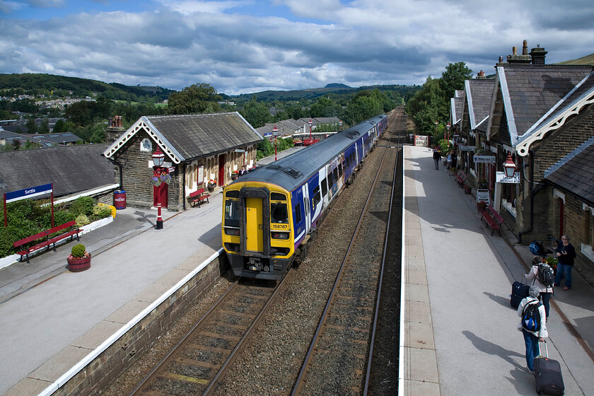 158787 & 158844, NT 10.49 Leeds-Carlisle (2H86), Settle station 
 The long drag begins! 158787 and 158844 leave Settle station working the 10.49 Leeds to Carlisle service commencing its climb up to Ais Gill summit at 1,167ft in some twenty-three miles time. I took a similarly angled photograph back during my visit to Settle in 1981 but from platform level, see.... https://www.ontheupfast.com/p/21936chg/29735524204/x47456-07-05-glasgow-central-nottingham 
 Keywords: 158787 158844 10.49 Leeds-Carlisle 2H86 Settle station Northern