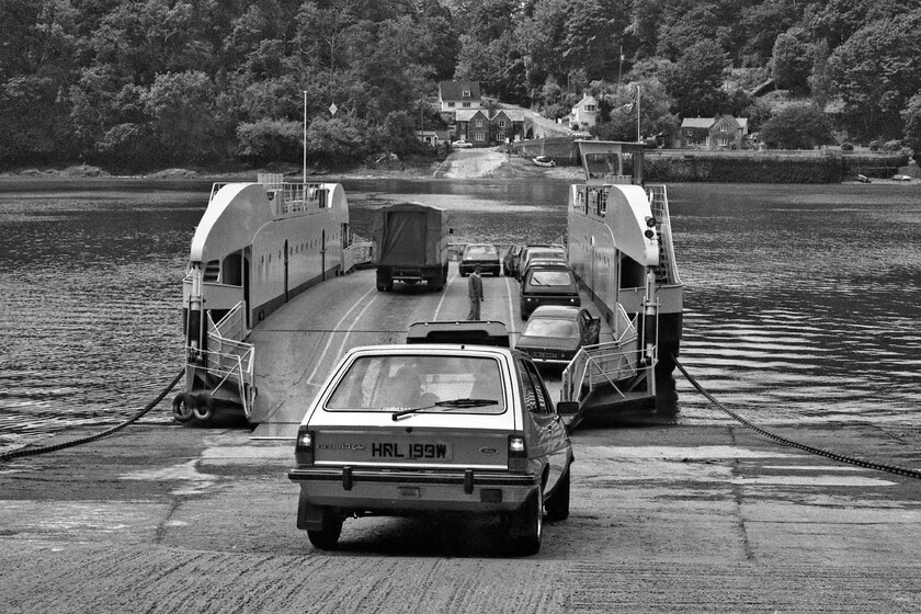 Loading King Harry Ferry 
 The King Harry Ferry is a vehicular chain ferry that has been in existence since 1888 which crosses the Carrick Roads that is part of the estuary of the River Fal. Back in 1981 ferry Number 6 is seen being loaded ready to cross to the western side of the estuary. This particular ferry was built in 1974 and was designed to carry twenty-three to twenty-eight cars. It stayed in operation until 2007 when ferry Number 7 replaced it. The blue Ford Fiesta 1.3 Ghia about to board the ferry was less than a year old when this photograph was taken, it was last on the road in 1995. 
 Keywords: Loading King Harry Ferry