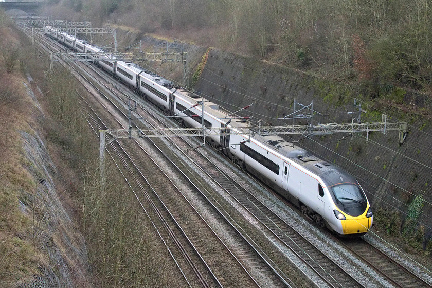 390124, VT 12.20 London Euston-Manchester Piccadilly (1H24, RT), Roade cutting 
 In a very dingy Roade cutting 390124 heads north on the afternoon of the last day of the year and the decade with the 1H24 Euston to Manchester Piccadilly service. 
 Keywords: 390124 12.20 London Euston-Manchester Piccadilly 1H24 Roade cutting Pendolino Avanti West Coast