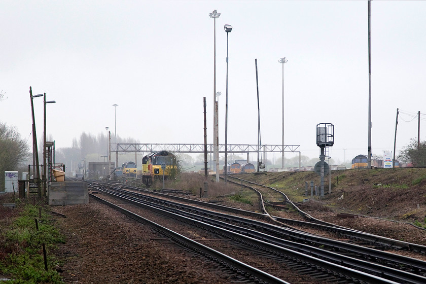 Class 70s & class 66s, stabled, Hoo Junction Yard 
 Taken from a public foot crossing on a track that goes down on to the remote Shorne Marshes, various stabled locomotives can be seen at Hoo Junction Yard. Unfortunately, no locomotives could be identified but there are at least two class 70s and a number of 66s. The two platforms of the staff only use Hoo Junction 'station' can be seen. 
 Keywords: Hoo Junction Yard