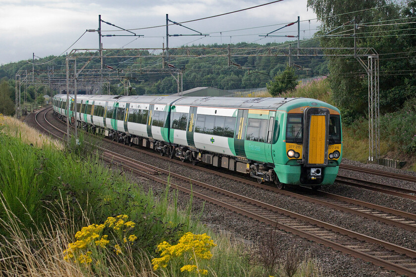 377215, SN 06.10 East Croydon-Milton Keynes Central (2M09, 1E), Old Linslade 
 On a grey and dull morning with spits and spots of rain (in Met. Office parlance), 377215 passes Old Linslade working the 06.10 East Croydon to Milton Keynes Southern service. Behind the rear set of this eight-car train the bridge that carries the former A4146 over the WCML can be seen and then beyond that the twin bores of Linslade tunnels. 
 Keywords: 377215 06.10 East Croydon-Milton Keynes Central 2M09 Old Linslade Southern