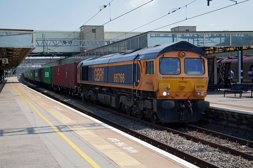 66766, 10.46 Felixstowe North-Hams Hall (4M23), Milton Keynes station 
 GBRF's 66766 speeds through Milton Keynes station leading the fully laden 4M23 10.46 Felixstowe North to Hams Hall Freightliner. Another shot taken the wrong side for the sun and in very tricky high summer lighting. 
 Keywords: 66766 10.46 Felixstowe North-Hams Hall 4M23 Milton Keynes station