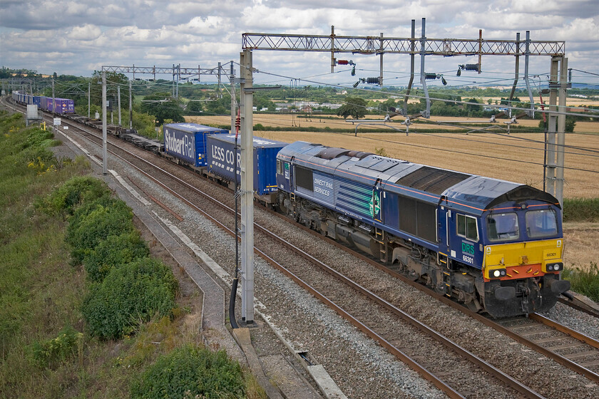 66301, 10.58 DIRFT-Purfleet (via Weedon) (4L48), Blisworth 
 I was hoping that the Class 66 would have fitted in between the wiring posts and if I had pressed the shutter a fraction earlier it may have done so....? 66301 leads the diverted SuO 4L48 10.58 Daventry to Purfleet Tesco Express. This train's journey started from the railfreight terminal heading north the short distance to Rugby. Then, the locomotive ran round the train for it to lead the train south towards its Thames Estuary destination. 
 Keywords: 66301, 10.58 DIRFT-Purfleet via Weedon 4L48 Blisworth Tesco Express