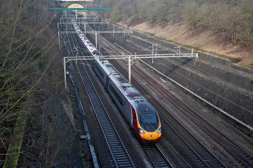 390118, VT 10.58 Preston-London Euston (1A16, 3E), Roade Cutting 
 In winter there is limited light in the depths of Roade Cutting. Photography is difficult unless there is strong sunlight to provide enough ambient light. The sun only illuminates the cutting directly for a few hours around midday. Here, 390118 'Virgin Princess' speeds through the cutting forming the 10.58 Preston to London Euston (1A16) working. 
 Keywords: 390118 1A16, Roade Cutting