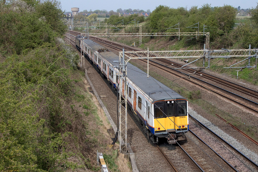 315816 & 57301, 10.56 Wembley yard-Masborough Booths (5Q25, 15E), Victoria bridge 
 Having spent its entire forty-years working life in the north London area carrying millions of commuters in and out of the capital, here 315816 is making its final journey to the scrap man at Booth's in Masborough (Rotherham). It is seen on the down fast line at Victoria bridge just south of Roade being towed as the 5Q25 by 57301 'Goliath'. I think that it's safe to say that the railways have had their money's worth out of these BREL (York) built units and one wonders if their replacements, the Bombardier Aventras, will do such a good job? 
 Keywords: 315816 57301 10.56 Wembley yard-Masborough Booths 5Q25 Victoria bridge Goliath Greater Anglia ROG scrap