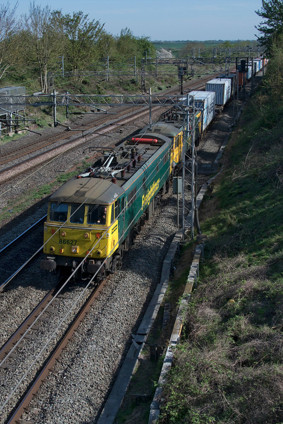 86627 & 86622, 11.13 Felixstowe North-Trafford Park (4M87, 20E), Victoria bridge 
 Under glorious afternoon skies, 86627 and 86622 lead the 11.13 Felixstowe to Trafford Park 4M87 Freightliner service. The veteran ac electrics are passing Victoria bridge near Roade on the down fast line. Whilst this was very rare up to about a month ago, now it is common practice. With the massively reduced timetable control have so many gaps that they can allow freight services in between passenger trains. 
 Keywords: 86627 86622 11.13 Felixstowe North-Trafford Park 4M87 Victoria bridge