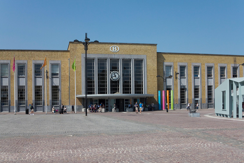 Frontage, Bruges station 
 This station building at Brugge was opened in 1939. It's a busy and impressive station that has gone through a vast expansion and refurbishment in recent years to accommodate the huge numbers who use it in order to visit the nearby medieval town (as we did!). Notice the corporate image logo of Belgian Railways at the top of the building. This classic logo that is seen all over the railway network, was designed in 1936 by Henry van de Velde and has remained exactly the same even since.