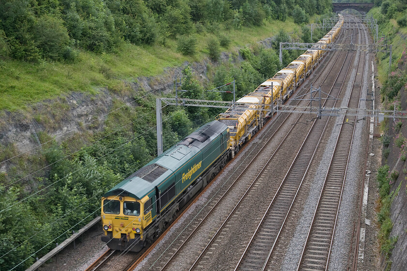 66561, 07.30 Birmingham lnternational-Willesden HOBC (6Y47), Roade cutting 
 The rear of the 07.30 Birmingham International to Willesden HOBC train makes its way south through Roade cutting with 66561 doing its best to shove the huge train from the rear. 
 Keywords: 66561 07.30 Birmingham lnternational-Willesden HOBC 6Y47 Roade cutting Freightliner High Output ballast cleaner