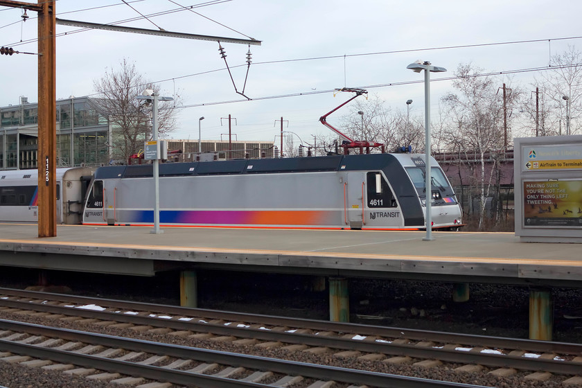 4611, 13.44 Trenton-New York Penn (3850), Newark International Airport station 
 An ALP-46 number 4611 brings up the rear of the 13.44 Trenton to New York Penn 3850 service. In my limited experience of NJ Transit Rail their trains were clean, on-time and 'functional'. By this, I mean that the interiors were less than luxurious than our trains with vinyl seat coverings and linoleum flooring. To the left in the background is the glass terminal building for the elevated AirTrain to the Newark International airport terminals. 
 Keywords: 4611 13.44 Trenton-New York Penn 3850 Newark International Airport station