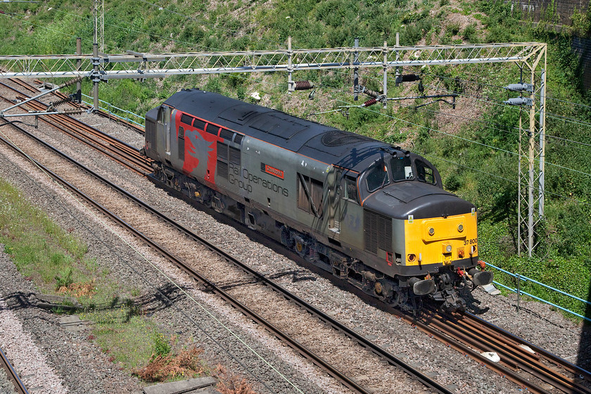 37800, 11.13 Leicester LIP-Ilford EMUD (0L50, 3E), Ashton Road bridge 
 From Ashton Road bridge Europhoenix's 37800 'Cassiopeia' runs light engine from Rail Operation Group's depot at Leicester as 0L50. It is heading to Ilford depot in East London adjacent to the Great Eastern mainline. In the late afternoon, it will collect a Class 317 unit from Greater Anglia that it will drag overnight to Wabtec in Kilmarnock. Despite being nearly sixty years old these veteran Type 3s still are very much in evidence and going competently about their business which is an astounding feat all things considered! 
 Keywords: 37800 11.13 Leicester LIP-Ilford EMUD 0L50 Ashton Road bridge ROG Rail Operation Group Cassiopeia Europhoenix Phoenix Rail