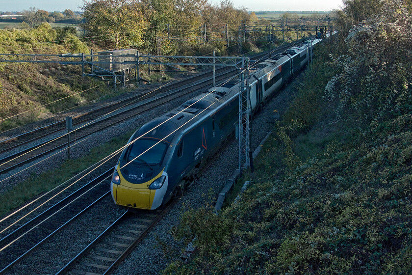 390008, 13.02 London Euston-Liverpool Lime Street (1F18, 13L), Victoria bridge 
 The perils of photographing when the sun is so low in the sky! Outside of the winter months, this view is lit on a sunny day, if a little from the side, but not well into November. 390008 'Charles Rennie Mackintosh' passes Victoria bridge just south of Roade working the 1F18 13.02 Euston to Liverpool Lime Street service. 
 Keywords: Charles Rennie Mackintosh 390008 13.02 London Euston-Liverpool Lime Street 1F18 Victoria bridge