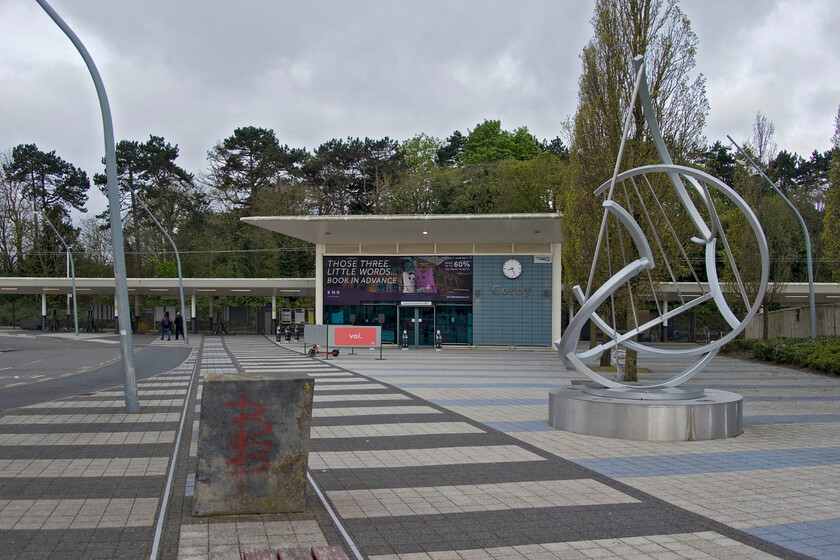 Frontage, Corby station 
 The story of Corby's railway station has been a tale of a number of openings and closures! The latest station, seen here, is on the same site as the previous ones and opened in February 2009. It was the third example of a modular station design developed by Network Rail, following Mitcham Eastfields and Greenhithe but did not draw universal applause for its design, notably from the Commission for Architecture and the Built Environment who really did not like it! Prior to its re-opening in 2009 it was claimed that Corby was one of the largest towns in Europe without a railway station (according to the Independent) following the closure of the previous one in 1990 that had only opened in 1987 offering a well-patronised but poorly operated DMU service to Kettering. Before this date, the initial Midland Railway built station closed in 1966 after opening in 1879 all at the same location. Notice the odd verticals of the concrete block and the lamposts in this image. This is not as a result of me or the camera's lens but by design; very odd! 
 Keywords: Frontage, Corby station