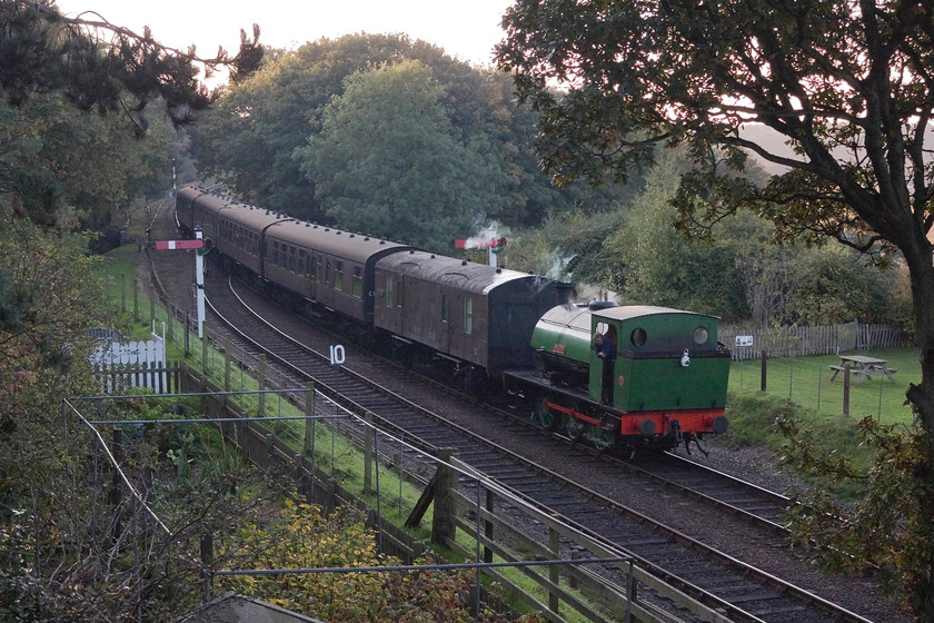 1982, 16.20 Holt-Sheringham, Weybourne 
 Having operated all the steam services throughout the day, 1982 'Ring Haw' drifts into Weybourne station with the last service train of the day, the 16.20 Holt to Sheringham. In the foreground is the small allotment and reproduction Anderson shelter that is part of Weybourne station. The narrow pathway between the allotment and the embankment is a great spot for taking pictures. 
 Keywords: 1982 16.20 Holt-Sheringham Weybourne