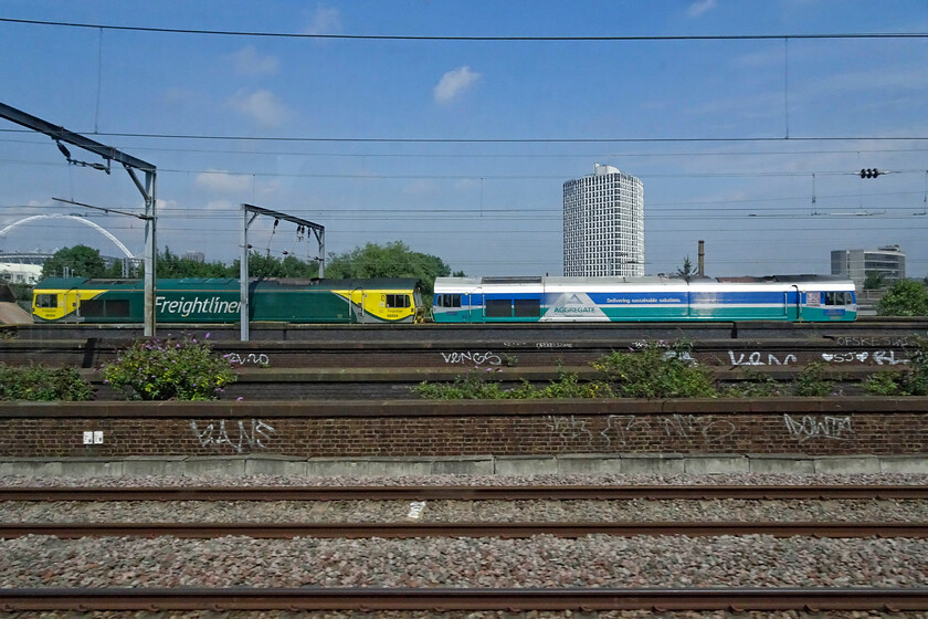 66504 & 59004, unidentified empty stone train, Wembley Yard 
 On our way up to London the previous day there was nothing to see in Wembley Yard. On our return, there were a number of wagons and trains that appeared to be laying over with just two locomotives in evidence. 66504 and 59004 'Paul A Hammond' are captured broadside leading a rake of empty stone wagons. With nothing obvious on RTT and my friend, Mike, unable to offer me anything from TOPS the train will remain unidentified. I suspect that it would be heading west back to Westbury and then on to one of the Mendip quarries. 
 Keywords: Paul A Hammond 66504 59004 empty stone train Wembley Yard