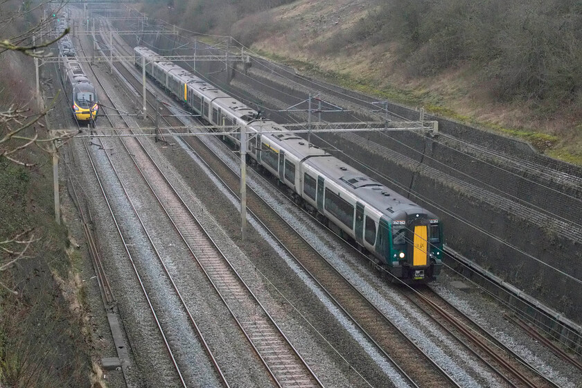 350262, LN 13.05 Northampton-London Euston (2N08, 2E) & 390112, VT 12.35 London Euston-Manchester Piccadilly (1H67, 2L), Roade cutting 
 350112 leads a classmate through Roade cutting working London Northwestern's 13.05 Northampton to Euston service. 390112 has just passed under where I am standing in Roade cutting working Avanti's 12.35 Euston to Manchester train. Notice the clearance of the embankment above the middle of the Class 350. This marks the spot where a huge new bridge will span the cutting carrying Roade's new, but much needed, bypass that will, unfortunately, ruin this viewpoint! 
 Keywords: 350262 13.05 Northampton-London Euston 2N08 390112 12.35 London Euston-Manchester Piccadilly 1H67 Roade cutting Avanti West Coast London Northwestern